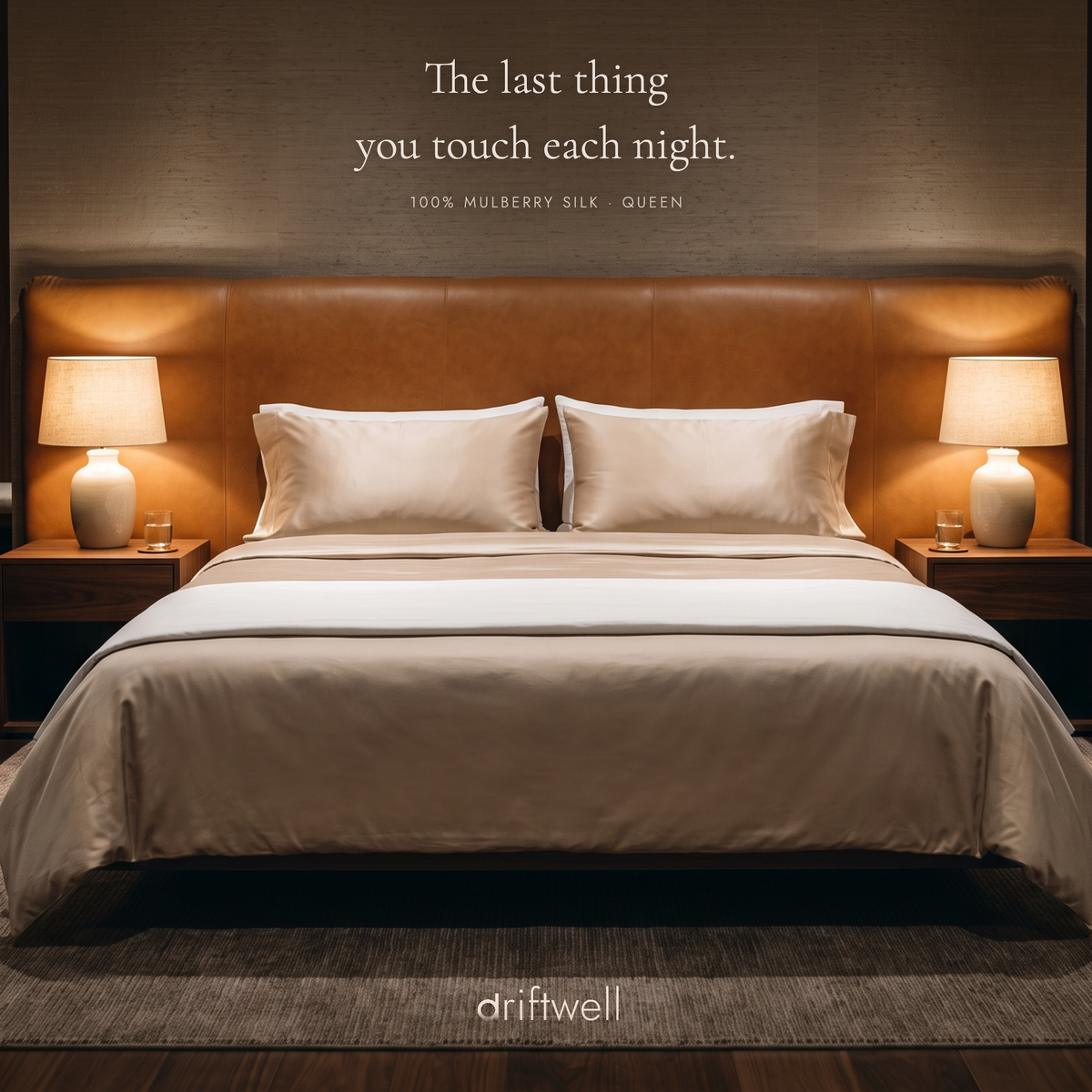 Driftwell silk pillowcase on a made bed in a warm, lamplit bedroom