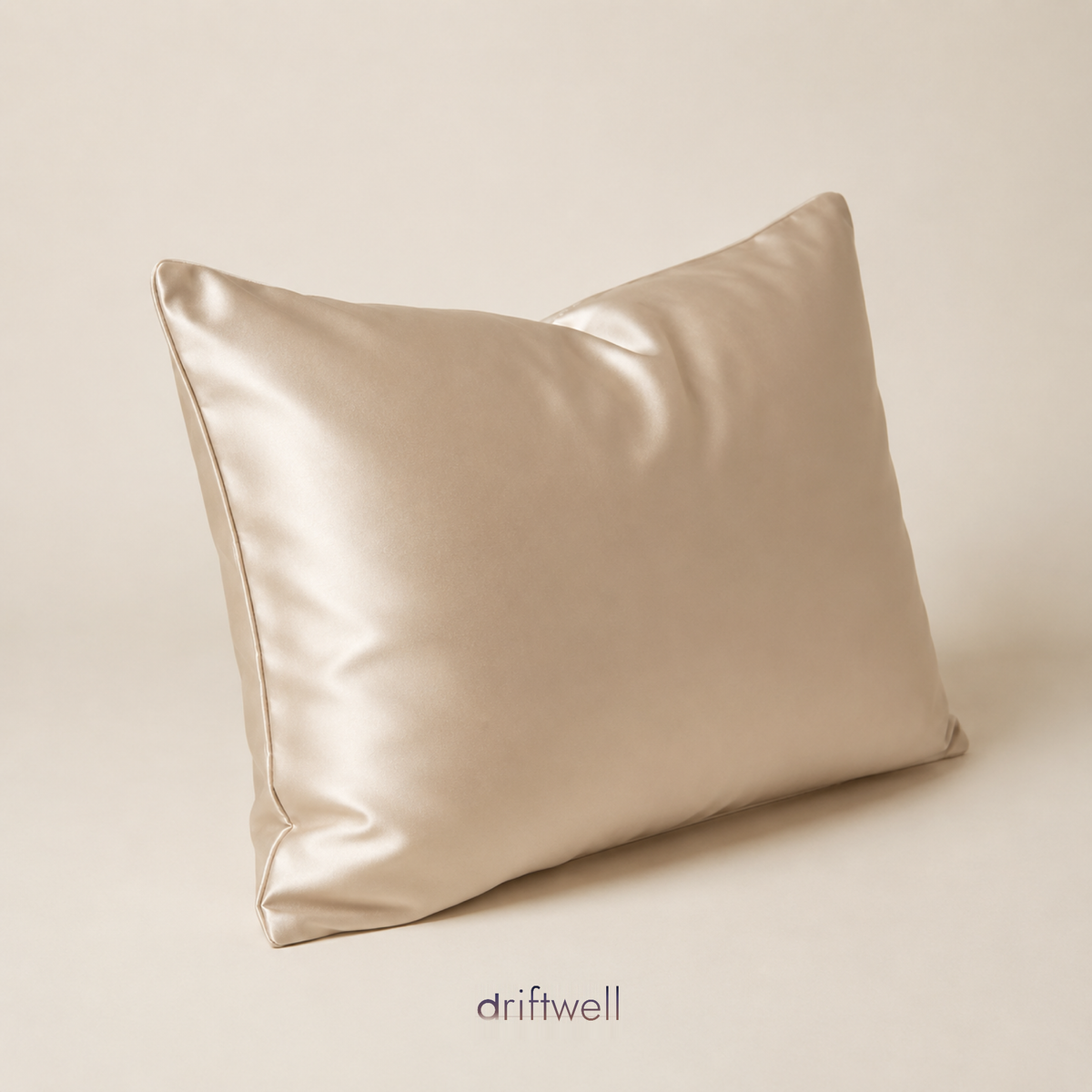 Driftwell 100% mulberry silk pillowcase in champagne, on a plain bone background