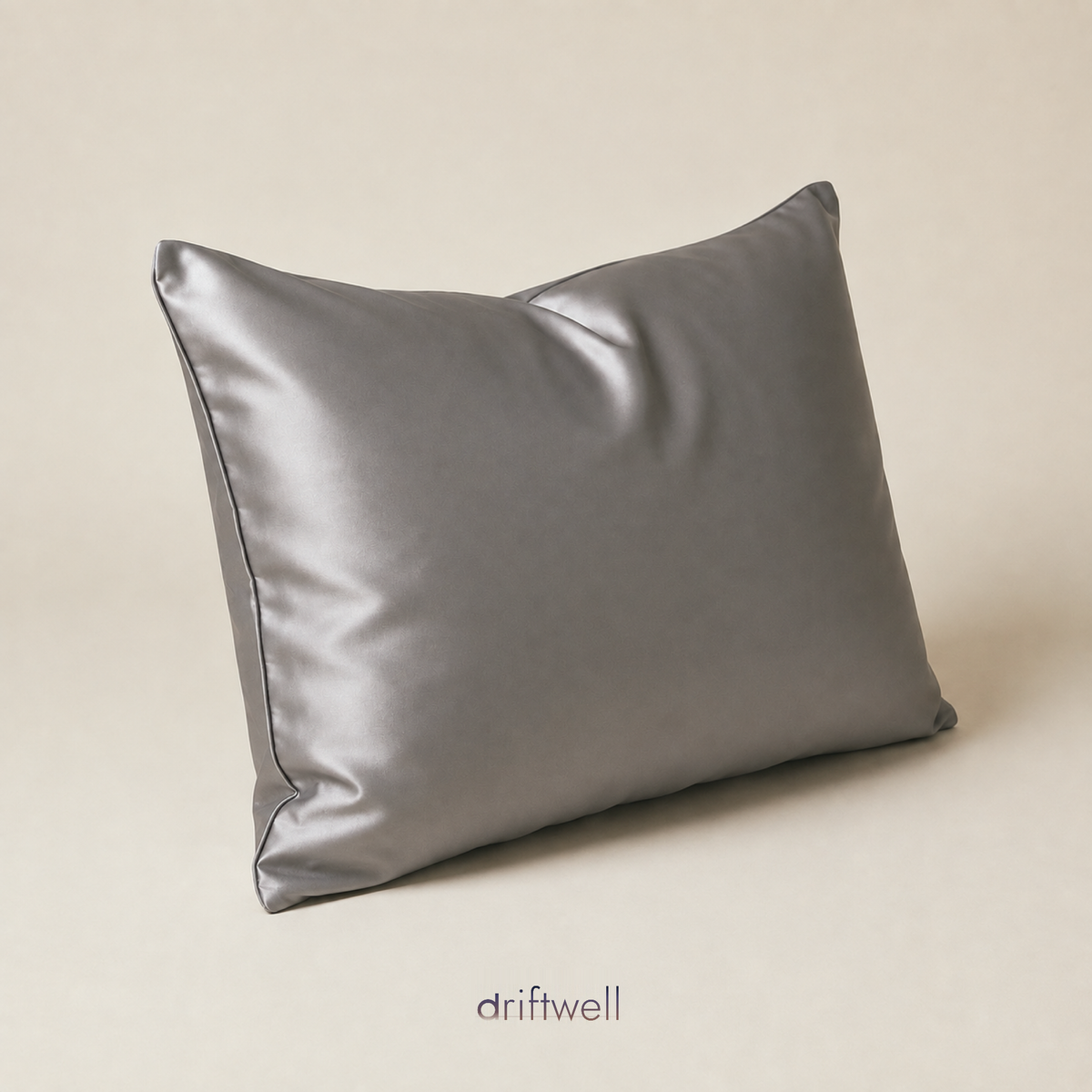Driftwell 100% mulberry silk pillowcase in dark gray, on a plain bone background