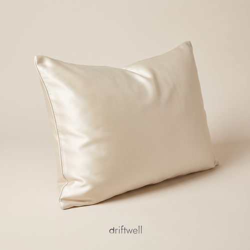 Driftwell 100% mulberry silk pillowcase in ivory, on a plain bone background