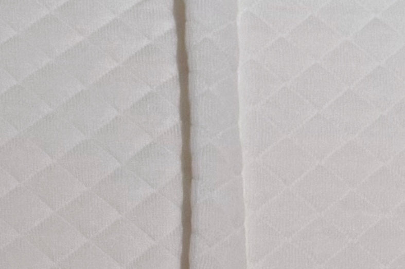 Close-up of the piped seam running through the quilted knit