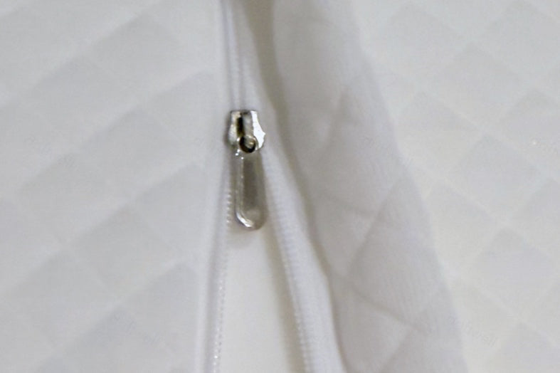 Close-up of the zip and its pull running along the edge of the quilted cover